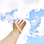 hand reaching out to clouds
