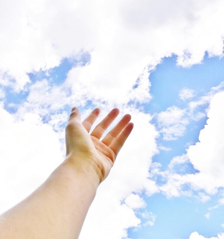 hand reaching out to clouds