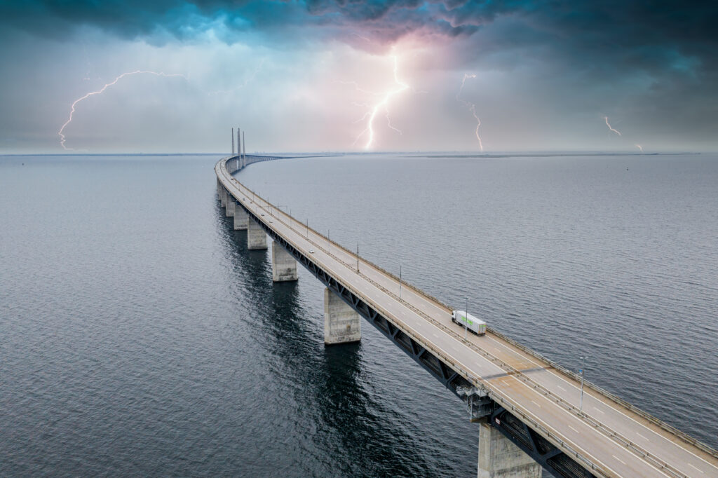 mesmerizing aerial view of the bridge between denmark and sweden under the sky with lightning